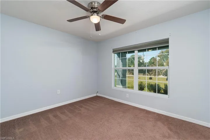 Unfurnished room featuring carpet and ceiling fan