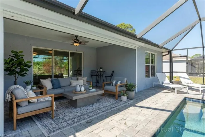 Sunroom featuring a patio, outdoor furniture, and ceiling fan (Digitally Staged)