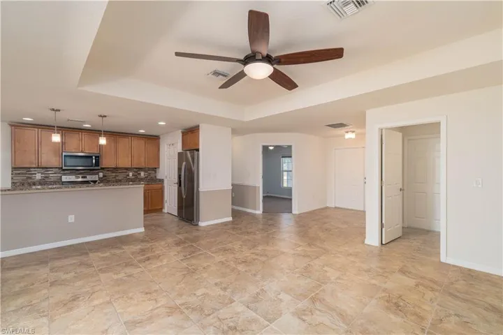 Kitchen with hanging light fixtures, a ceiling fan, open floor plan, tasteful backsplash, and stainless steel appliances