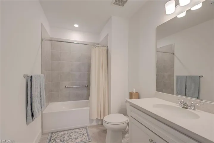 Bathroom with vanity, light tile flooring, and shower / bath combo
