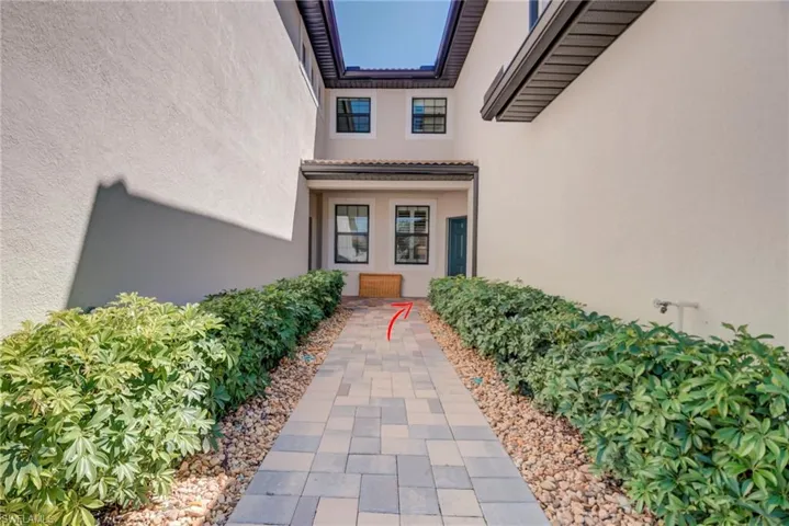 View of shared walk-way to entry featuring stucco siding