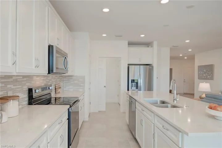 Kitchen with stainless steel appliances, recessed lighting, white cabinets, quartz countertops and pull out shelves!