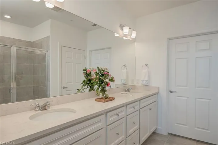 Master bath featuring double vanity, a walk-in shower, and plenty of cupboards and drawer space