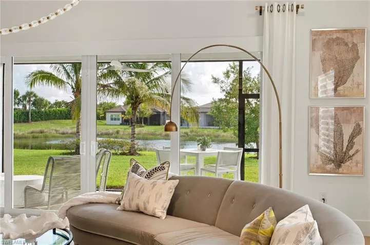 Floor-to-ceiling sliding glass doors, screen-enclosed patio, and pond-side setting