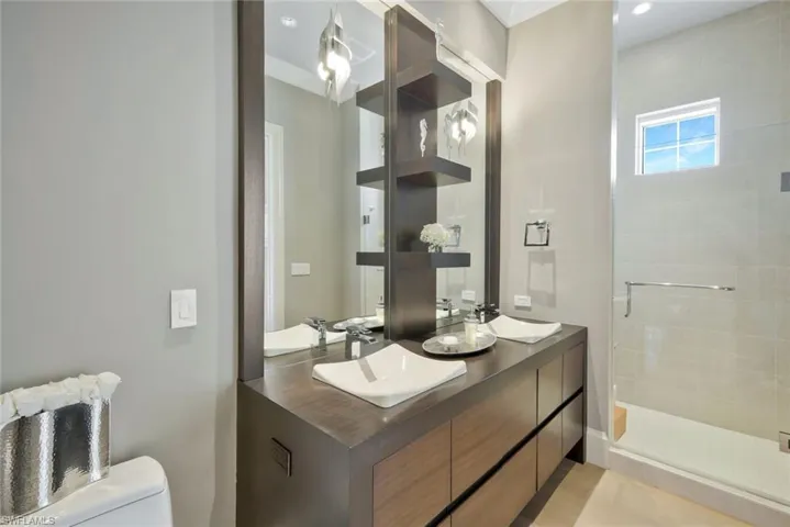 Guest bathroom with a walk in shower and dual sinks.