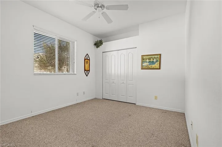 bedroom #2 with ceiling fan, a closet, and light colored carpet