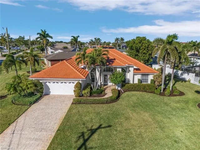Mediterranean / spanish house featuring a garage and a front lawn