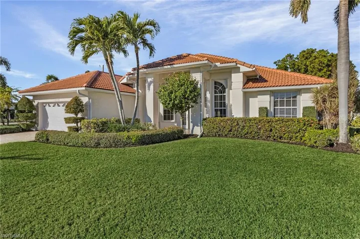 Mediterranean / spanish home featuring a garage and a front yard