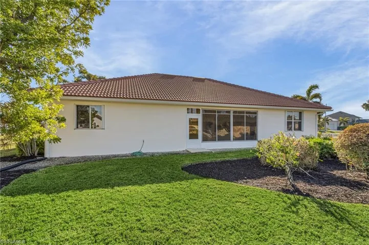 Back of property featuring a lawn