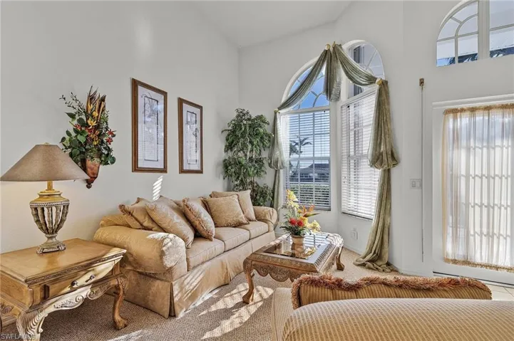 Carpeted living room featuring a towering ceiling
