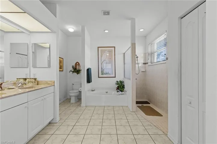 Full bathroom with tile patterned floors, vanity, toilet, and shower with separate bathtub