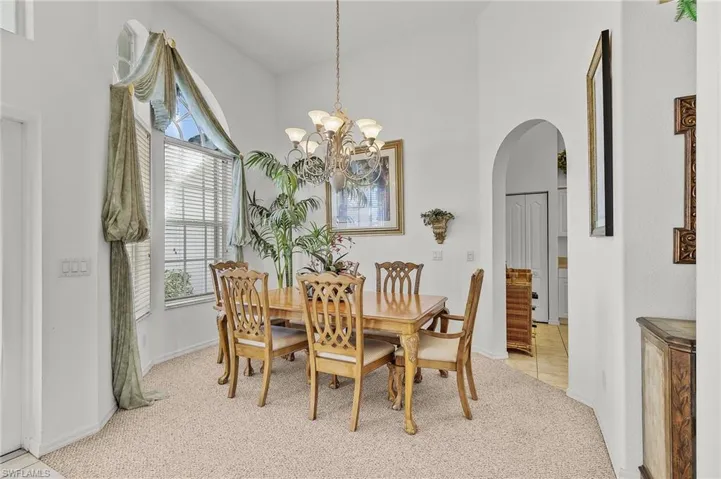 Carpeted dining space featuring a chandelier