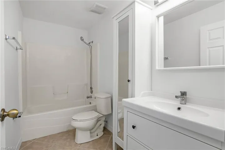 Full bath with visible vents, tile patterned flooring, vanity, toilet, and shower / bathtub combination