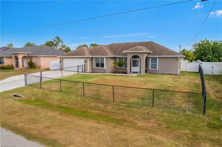 Single story home featuring a fenced backyard, a front lawn, concrete driveway, an attached garage, and stucco siding