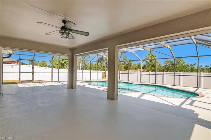 View of swimming pool with a patio, a ceiling fan, a fenced backyard, and a pool with connected hot tub