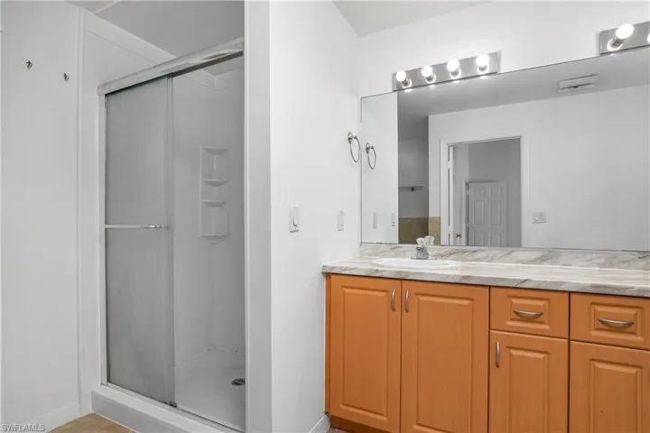 Full bathroom featuring vanity, baseboards, and a stall shower