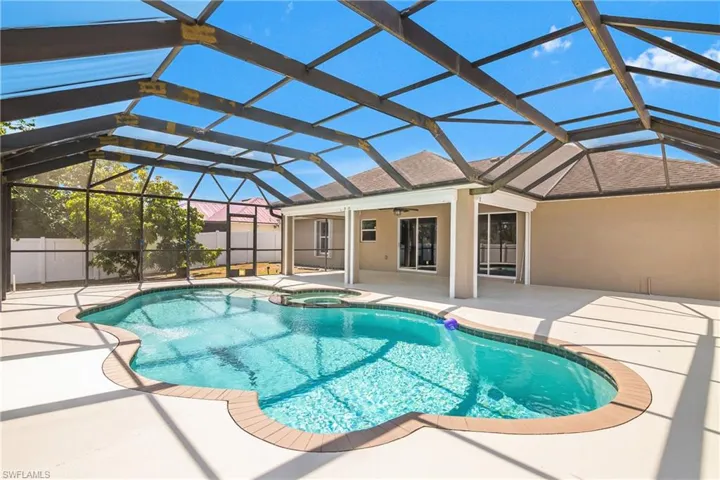 View of swimming pool with a fenced in pool, a ceiling fan, a patio, and an in ground hot tub