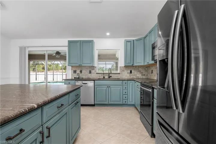 Kitchen featuring a sink, appliances with stainless steel finishes, plenty of natural light, and backsplash