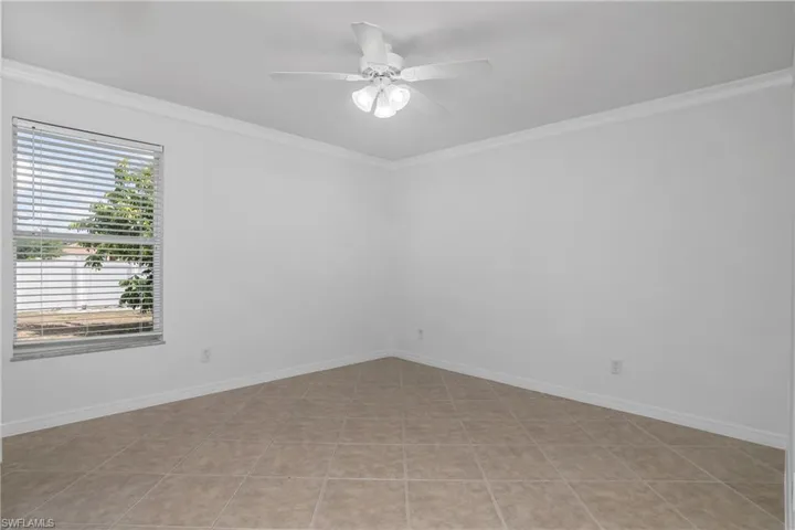 Unfurnished room with a ceiling fan and ornamental molding