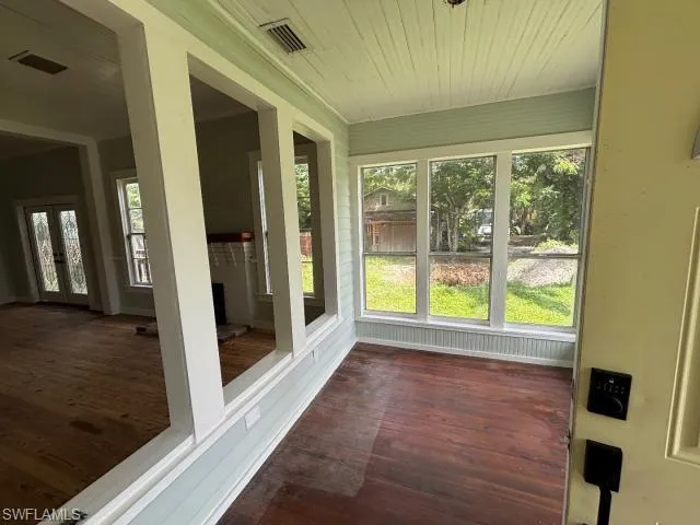Unfurnished sunroom with french doors, wood finished floors, and wood ceiling