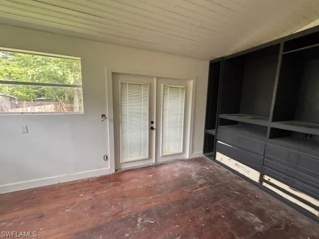 Unfurnished living room with wood ceiling and french doors