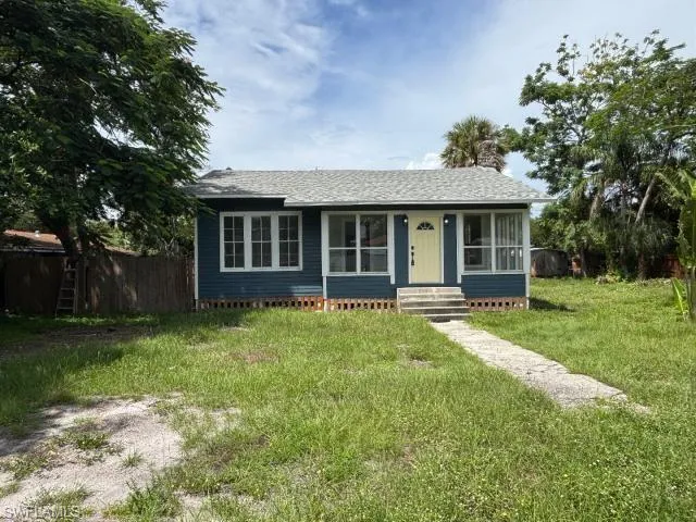 View of front facade featuring entry steps, roof with shingles, and a chimney