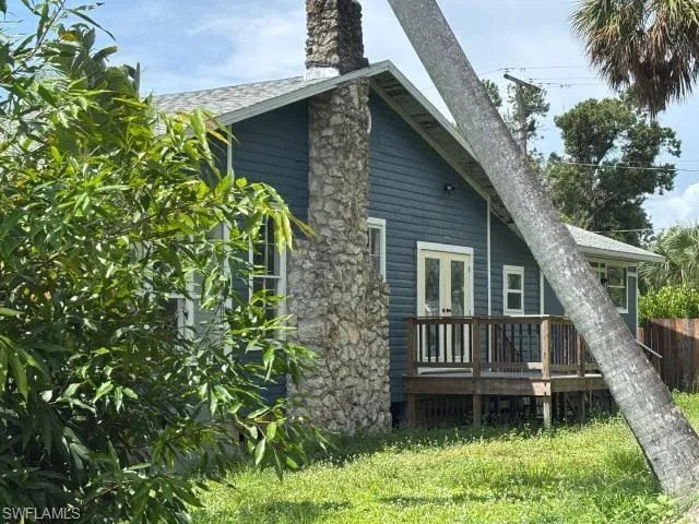 Rear view of property with a wooden deck, a chimney, and a shingled roof