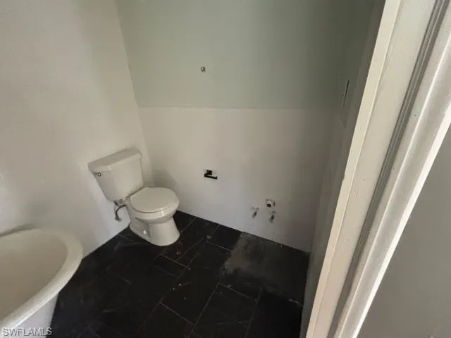 Bathroom featuring a soaking tub and dark tile patterned floors