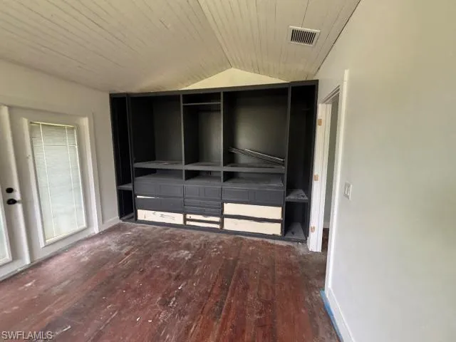 Unfurnished bedroom with dark wood-style floors, vaulted ceiling, and wood ceiling