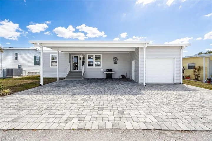 Ranch-style house featuring a patio, decorative driveway, an attached carport, and entry steps