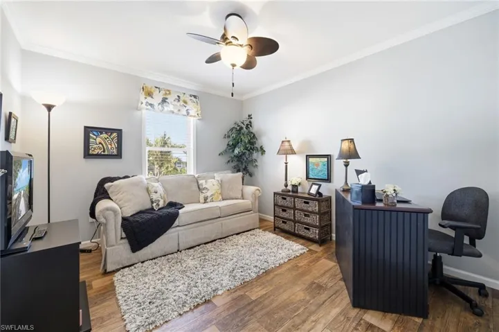 Office area with hardwood / wood-style floors, crown molding, and a ceiling fan