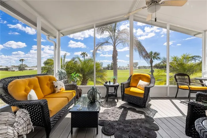 Sunroom featuring golf course view, an outdoor living space, and a ceiling fan