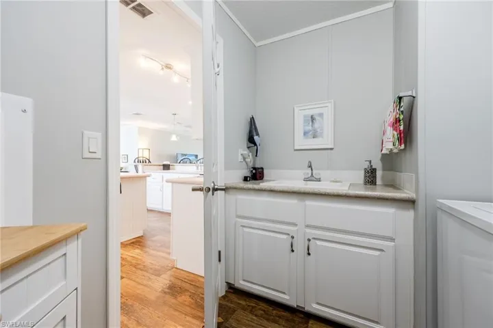Bathroom with vanity, light wood-style floors, and ornamental molding