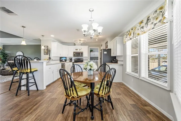 Dining area featuring crown molding, a chandelier, and dark wood-type flooring