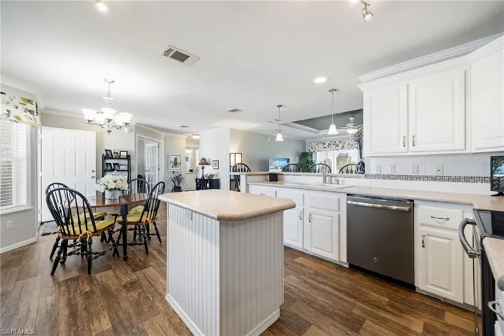 Kitchen featuring white cabinets, tasteful backsplash, dishwasher, electric stove, and dark wood-type flooring