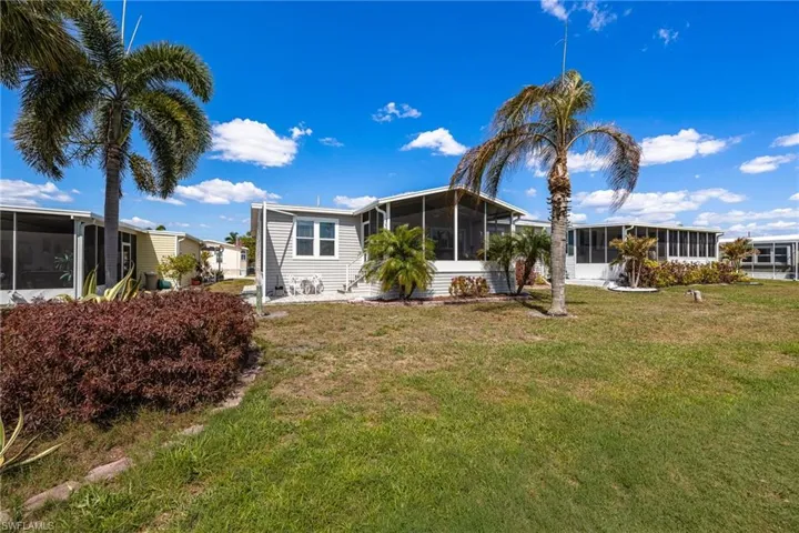 View of front of property with a sunroom and a front lawn