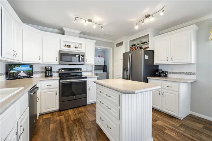 Kitchen with open shelves, stainless steel appliances, white cabinetry, and crown molding