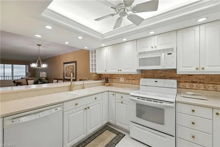 Kitchen featuring recessed lighting, crown molding, white appliances, a chandelier, and white cabinets