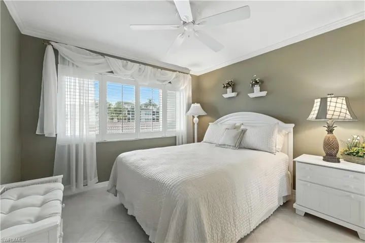 Bedroom with crown molding, ceiling fan, and light tile patterned floors