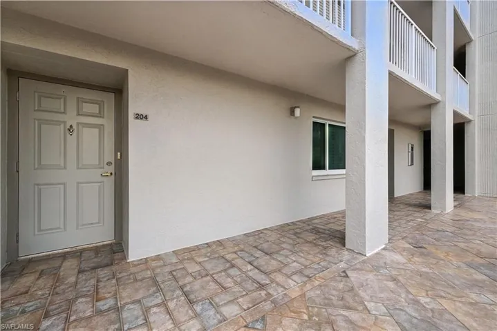 Property entrance with stucco siding and a patio