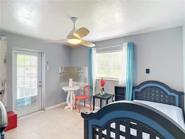 Room with tile flooring, a ceiling fan, and a glass-paneled door
