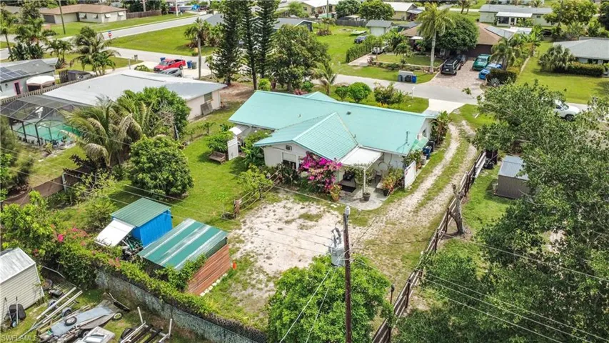 Single-story residence featuring a teal metal roof and a gravel driveway