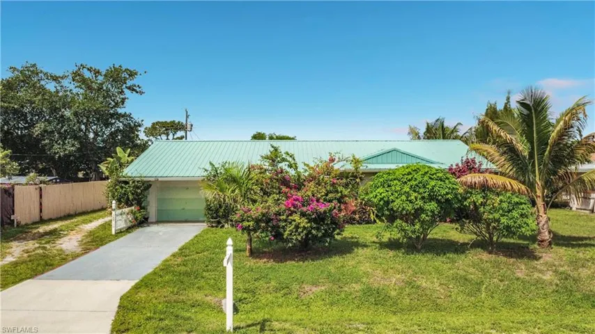 Single-story residence featuring a teal metal roof and an attached garage
