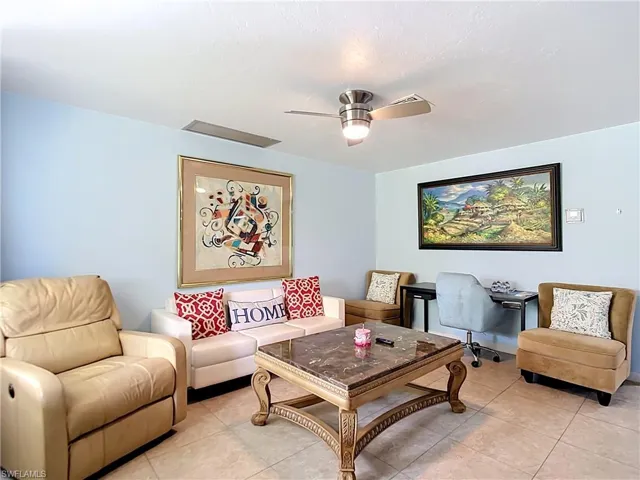 Living area featuring tile flooring, a ceiling fan with integrated lighting, and light blue wall finishes