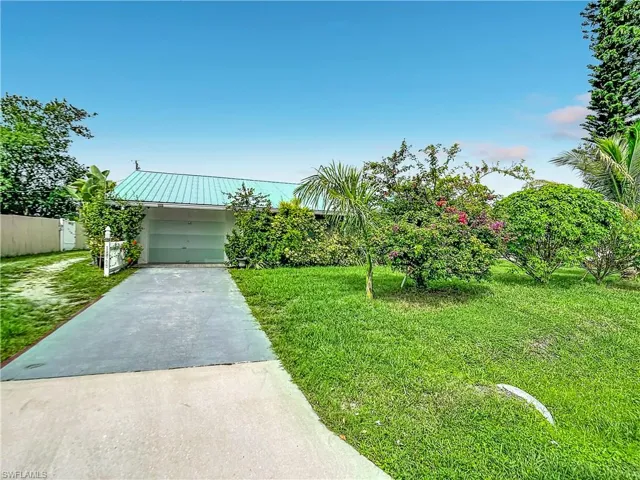 Single-story residence featuring a teal metal roof and an attached garage with a frosted glass door