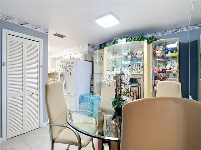 Dining area featuring a circular glass-top table, tile flooring, and integrated display cabinetry