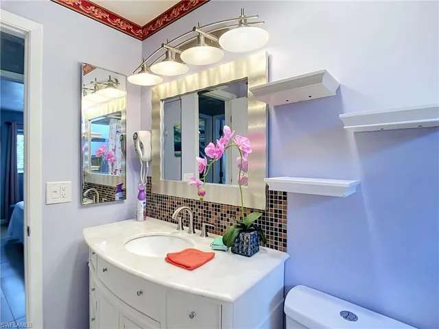 Vanity featuring a curved countertop, integrated sink, and brushed nickel faucet