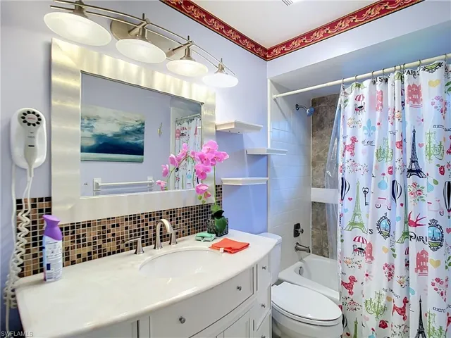 Bathroom vanity featuring a white curved countertop with an integrated sink and a chrome faucet