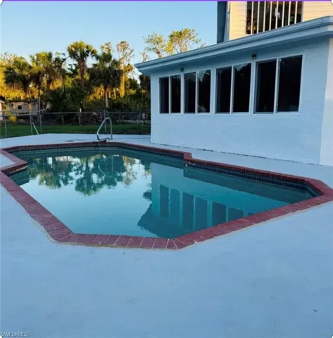 View of swimming pool featuring a patio area and a sunroom