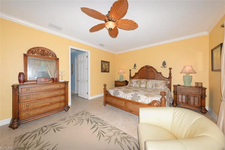 Large Primary Suite features, 20" tile flooring, Crown molding, large windows with views of the natural creek and preserve, a sitting area, door to the large Lanai, 2 walk-in closets and a beautiful en-suite bathroom.